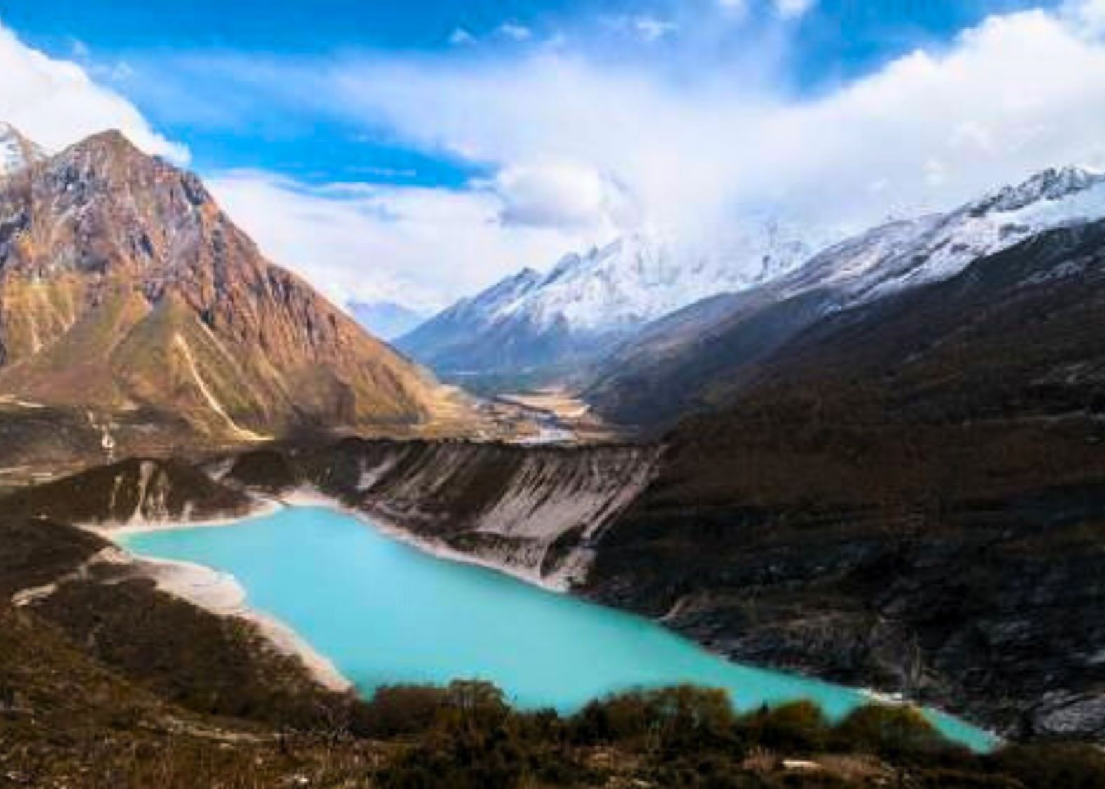Close-up of the stunning turquoise waters of Birendra Lake, with stone cairns visible on the shore.